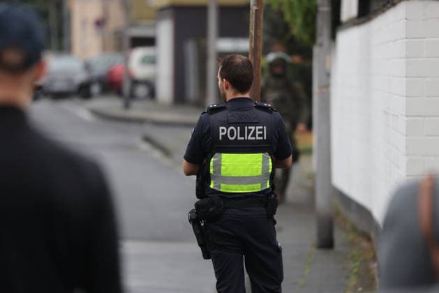 Police seal off Erlenhofstrasse in Cologne after reports of gunshots from attic COLOGNE, GERMANY - AUGUST 18: German police officers secure the cordoned-off perimeter around Erlenhofstrasse during an ongoing armed operation in the Niehl district of Cologne, Germany, on August 18, 2026. Following reports that a man fired gunshots into the air from an attic apartment, numerous police units were dispatched to the scene, shutting down Erlenhofstrasse and surrounding connecting roads to vehicular and pedestrian traffic while urging the public to avoid the area. Kadir Ilboga Anadolu Cologne Germany. Editorial use only. Please get in touch for any other usage.  Copyright: x2026xAnadoluxKadirxIlbogax