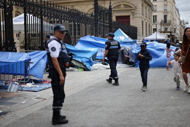 Homeless people camp outside the Paris Centre City Hall - Paris Police forces walk next to homeless people with children have set up their camp and have put up tents outside the Paris Centre City Hall, in Paris on August 18, 2026. After being removed from the forecourt of the Samu Social headquarters in Paris. Photo by Raphael Lafargue ABACAPRESS.COM Paris France  Copyright: xLafarguexRaphael ABACAx