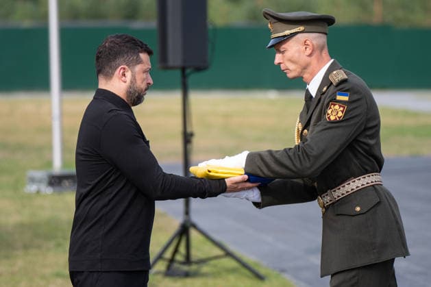 President of Ukraine Volodymyr Zelenskyy accepts a Ukrainian flag from an honour guard of the Ukrainian Armed Forces during the solemn reburial ceremony of Colonel Yevhen Konovalets, first head of the Organisation of Ukrainian Nationalists (OUN) and colonel of the Army of the Ukrainian People’s Republic (UNR), at the National Military Memorial Cemetery in Kyiv region, Ukraine, August 18, 2026. On August 11, 2026, Konovalets’ remains were exhumed at Crooswijk General Cemetery in Rotterdam, the Netherlands, where they had rested since his assassination by a Soviet agent in May 1938. (Photo by Danylo Antoniuk Ukrinform) Remains of OUN leader Yevhen Konovalets reburied at National Military Memorial Cemetery  Copyright: xDanyloxAntoniukx
