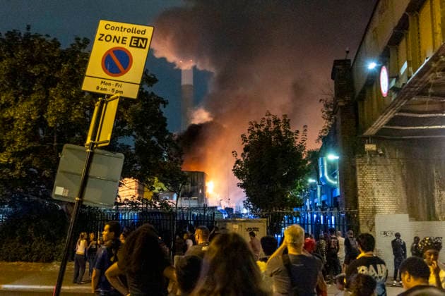 August 18, 2026, London, London, UK: London, UK. Members of the public watch the scene in Deptford south London after a huge fire in a waste facility. Fifteen fire engines and around 100 firefighters battle a blaze in Southwark. London UK  - ZUMAl94_ 20260818_zaf_l94_038 Copyright: xMarcinxNowakx