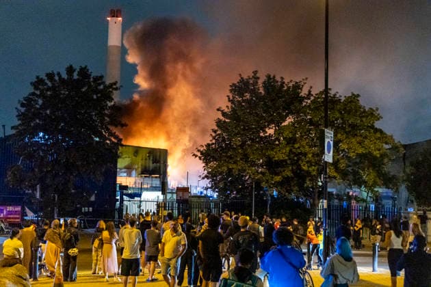 August 18, 2026, London, London, UK: London, UK. Members of the public watch the scene in Deptford south London after a huge fire in a waste facility. Fifteen fire engines and around 100 firefighters battle a blaze in Southwark. London UK  - ZUMAl94_ 20260818_zaf_l94_039 Copyright: xMarcinxNowakx