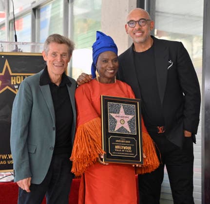 Five-time Grammy-winning Beninese musician, actress, and activist Angelique Kidjo holds a replica plaque as she is joined by actor Willem Dafoe (L) and Harvey Mason jr., CEO, the Recording Academy during an unveiling ceremony honoring her with the 2,854th star on the Hollywood Walk of Fame in Los Angeles on Tuesday, August 18, 2026.  LAP2026081813 JIMxRUYMEN