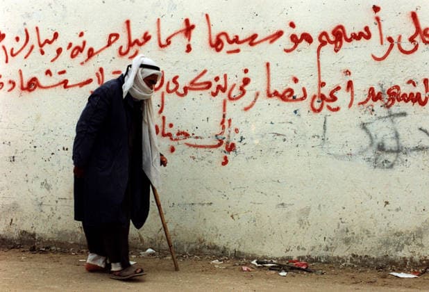 ISRAEL PALAESTINA : Alter Mann vor Wahlkampf - Graffiti in Gaza-Stadt , Januar 1996 ISRAEL PALESTINE : Shortly before the first elections in Palestine an old man is passing a wall full of political slogans , January 1996 *** ISRAEL PALESTINE An old man walks past election campaign graffiti in Gaza City, January 1996 ISRAEL PALESTINE Shortly before the first elections in Palestine, an old man walks past a wall covered with political slogans, January 1996