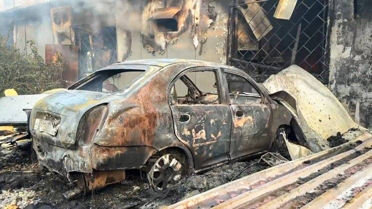 RUSSIA, LUGANSK - AUGUST 19, 2026: The burnt wreckage of a car remains outside a storage shed damaged by a Ukrainian military strike, with a car repair shop and a confectionery factory inside. Video screen grab. Best quality available. Danil Derkayev TASS  96343857