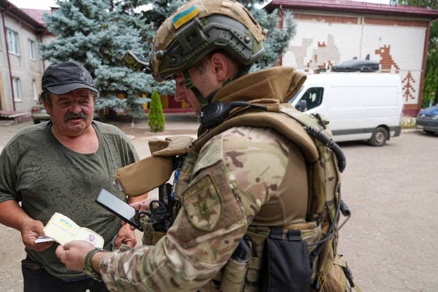 August 19, 2026, Sergeevka, Donetsk Oblast, Ukraine: Gennady Yudin, head of the White Angels crew in the Donetsk region, checks the documents of a civilian ready to be evacuated from the village of Sergeevka, east of Kramatorsk, in the Donbas region, Ukraine, on August 19, 2026. The White Angels crew, composed of police officers, evacuate people from the frontline towns and villages. Sergeevka Ukraine  - ZUMAa252 20260819_zip_a252_004 Copyright: xDavidxAllignonx