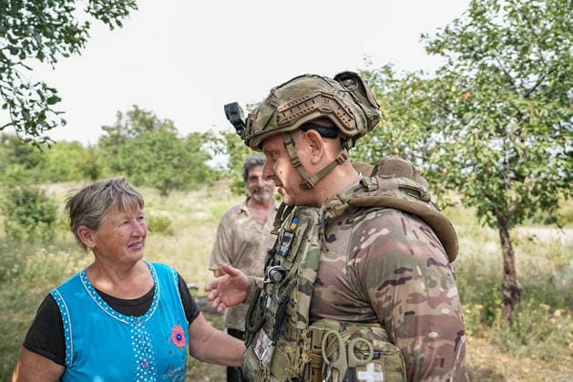 August 19, 2026, Serhiivka, Donetsk Oblast, Ukraine: Gennady Yudin, head of the White Angels crew in the Donetsk region, chats with a woman waiting to be evacuated from the village of Serhiivka, east of Kramatorsk, in the Donbas region, Ukraine, on August 19, 2026. The White Angels crew, composed of police officers, evacuate people from the frontline towns and villages. Serhiivka Ukraine  - ZUMAa252 20260819_zip_a252_009 Copyright: xDavidxAllignonx
