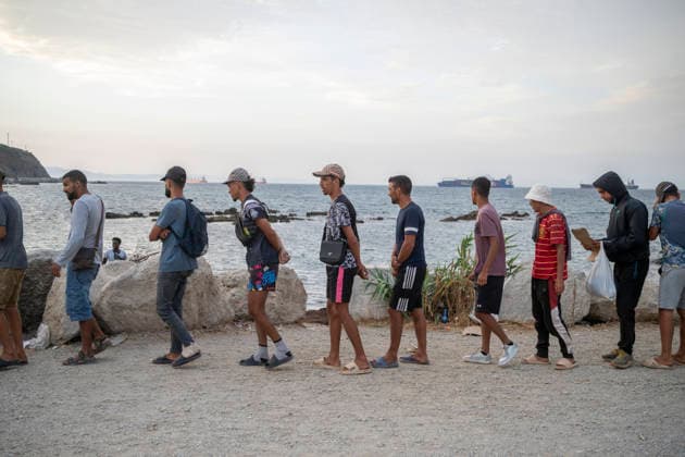 The humanitarian crisis in Ceuta continues. Several migrants wait in line for food on a beach on August 19, 2026, in Ceuta, Spain. Ceuta continues to face a serious humanitarian crisis following the historic mass influx of more than 70,000 migrants who swam across the Tarajal on July 30 and 31. Although the current police deployment and border reinforcement by by Moroccan authorities have managed to stem the influx, the autonomous city continues to face a serious humanitarian crisis, health, and security crises. AUGUST 19, 2026 CEUTA MIGRATION CRISIS MIGRANTS IMMIGRANTS TRAMPOLÍN TARAJAL PLAYA BENÍTEZ Ceuta Ceuta, Spain  Copyright: xMarcosxMorenox 7721839