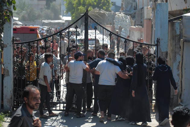 Gaza City Strike Kills Palestinians Palestinians gather behind a metal gate near the site of an Israeli strike near the municipal park in central Gaza City, the Gaza Strip, on August 19, 2026. At least nine Palestinians were killed and more than 15 others were wounded in the strike, including women and children, according to an initial toll. The strike came shortly after another Israeli attack targeted the municipal police command headquarters in Gaza City. Gaza Gaza Strip Palestinian Territories Copyright: xEyadxAzamx