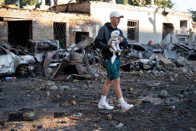 Ukraine says 12 people killed, 33 injured in Russia s overnight strike on Kyiv KYIV, UKRAINE - AUGUST 20: A man carrying a dog walks past damaged vehicles and debris following an overnight Russian attack on Kyiv, Ukraine, on August 20, 2026. Based on preliminary information provided by Kyiv Mayor Vitali Klitschko, at least 12 people were killed and 33 others wounded, while the Darnytskyi, Sviatoshynskyi and Solomianskyi districts sustained damage. Stringer Anadolu Kyiv Ukraine. Editorial use only. Please get in touch for any other usage.  Copyright: x2026xAnadoluxStringerx