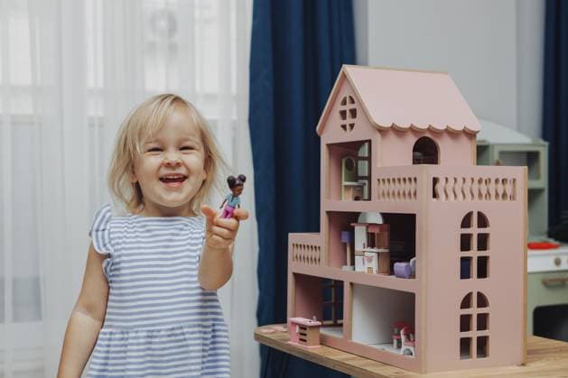 Ein kleines Mädchen im blauen Kleid arrangiert Holzmöbel in einem Puppenhaus. Konzept der Bildung während des Spiels Child girl in blue dress arranges wooden furniture in a doll house. Concept of education during the game Copyright: imageBROKER AlinaxKandybka ibxayk18797881.jpg ,model released, Symbolfoto ,property released