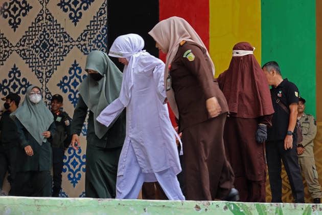 August 20, 2026, Banda Aceh, Aceh, Indonesia: A woman is helped to walk by officials after undergoing a public caning in Taman Sari, Banda Aceh, Aceh Province, Indonesia, on Thursday, August 20, 2026. The Banda Aceh Sharia Court sentenced 11 people to between 7 and 100 lashes for violating Islamic Sharia. Banda Aceh Indonesia  - ZUMAs340 20260820_zip_s340_016 Copyright: xKhairuxSyukrillahx