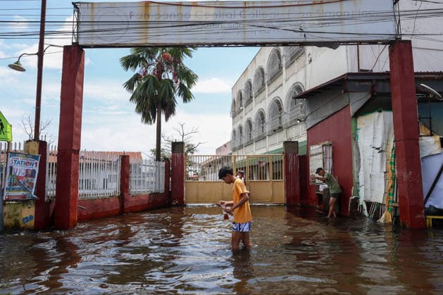 Monsoon rains flood multiple places in Philippines as tens of thousands displaced PAMPANGA, PHILIPPINES - AUGUST 20: 17-year-old Herald Cruz (C) wades through a flooded street outside his flooded college due to monsoon rains, in Apalit, Pampanga, Philippines, on August 20, 2026. The lingering monsoon effects, compounded with the intensifying tropical storm Saudel that is expected to turn into a typhoon, have recently brought humongous rains to the Philippines, causing widespread, serious flooding in multiple areas across 10 different regions, including those on Central Luzon. As a result, tens of thousands of people across the Southeast Asian country have been displaced or evacuated to safety. Daniel Ceng Anadolu Pampanga Philippines. Edi  Copyright: x2026xAnadoluxDanielxCengx