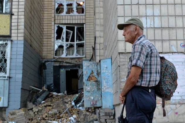 An elderly man with a backpack and a bag stands outside an apartment block in the Solomianskyi district, damaged by a Russian missile attack, Kyiv, Ukraine, August 20, 2026. High-rise residential buildings, a children’s hospital, a school, utility and warehouse facilities, garages, and cars were damaged in the district as a result of Russia’s overnight large-scale combined strike on the capital. Power grid infrastructure was also affected, causing an outage. In Kyiv, the attack claimed the lives of at least 13 people, including two children. The Russian military targeted the city with ballistic missiles, Kalibr cruise missiles, Kh-101s, and Zircon hypersonic cruise missiles. (Photo by Oleksandr Klymenko Ukrinform) Aftermath of Russian strik  Copyright: xOleksandrxKlymenkox