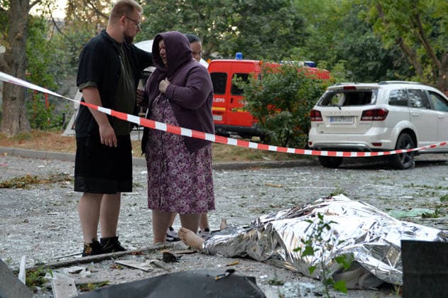 Russian Strikes Kill 14 In Kyiv And Region - Kyiv Region (EDITORS NOTE: Image contains graphic content.) A man comforts a woman crying by the body of a victim covered with a space blanket outside an apartment block in the Solomianskyi district, damaged by a Russian missile attack, Kyiv, Ukraine, August 20, 2026. High-rise residential buildings, a children? hospital, a school, utility and warehouse facilities, garages, and cars were damaged in the district as a result of Russia? overnight large-scale combined strike on the capital. Power grid infrastructure was also affected, causing an outage. In Kyiv, the attack claimed the lives of at least 13 people, including two children. The Russian military targeted the city with ballistic missiles,  Copyright: xKlymenkoxOleksandr Ukrinform ABACAx