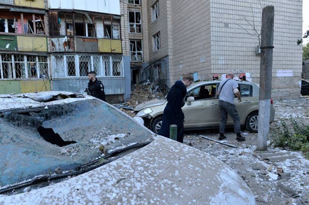 Aftermath of Russian strike in Solomianskyi district of Kyiv First responders and people stay by cars outside an apartment block in the Solomianskyi district in Kyiv, Ukraine, on August 20, 2026. High-rise residential buildings, a children s hospital, a school, utility and warehouse facilities, garages, and cars were damaged in the district following an overnight large-scale combined strike on the capital. Power grid infrastructure was also affected, causing an outage. The attack claimed the lives of at least 13 people in Kyiv, including two children. The strike involved ballistic missiles, Kalibr cruise missiles, Kh-101s, and Zircon hypersonic cruise missiles. Kyiv Ukraine  Copyright: xDanyloxAntoniukx originalFilename: ukrinform-aftermat260820_npEHu.jpg