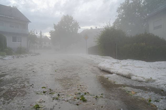 Hagelmassen in Monheim: Menschen greifen zu Schneeschippen, Heftige Unwetter haben in Monheim große Mengen Hagel niedergehen lassen. Straßen, Gehwege und Grundstücke waren stellenweise von einer dicken Schicht aus Hagelkörnern bedeckt das Bild erinnerte mitten im Sommer zeitweise an eine Winterlandschaft. Besonders eindrucksvoll: Anwohner greifen zu Schneeschippen und versuchen, die Hagelmassen von Straßen und Einfahrten zu räumen. Die ungewöhnlichen Bilder zeigen, welche Mengen innerhalb kurzer Zeit vom Himmel gefallen sind. Monheim Bayern Deutschland Monheim *** Heavy Hail in Monheim: People Grab Snow Shovels, Severe storms have dumped large amounts of hail in Monheim. Streets, sidewalks, and yards were covered in places by a t Copyright: x xonw-imagesx xSimonxZeiherx