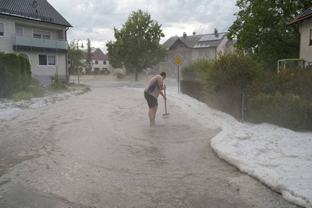 Hagelmassen in Monheim: Menschen greifen zu Schneeschippen, Heftige Unwetter haben in Monheim große Mengen Hagel niedergehen lassen. Straßen, Gehwege und Grundstücke waren stellenweise von einer dicken Schicht aus Hagelkörnern bedeckt das Bild erinnerte mitten im Sommer zeitweise an eine Winterlandschaft. Besonders eindrucksvoll: Anwohner greifen zu Schneeschippen und versuchen, die Hagelmassen von Straßen und Einfahrten zu räumen. Die ungewöhnlichen Bilder zeigen, welche Mengen innerhalb kurzer Zeit vom Himmel gefallen sind. Monheim Bayern Deutschland Monheim *** Heavy Hail in Monheim: People Grab Snow Shovels, Severe storms have dumped large amounts of hail in Monheim. Streets, sidewalks, and yards were covered in places by a t Copyright: x xonw-imagesx xSimonxZeiherx
