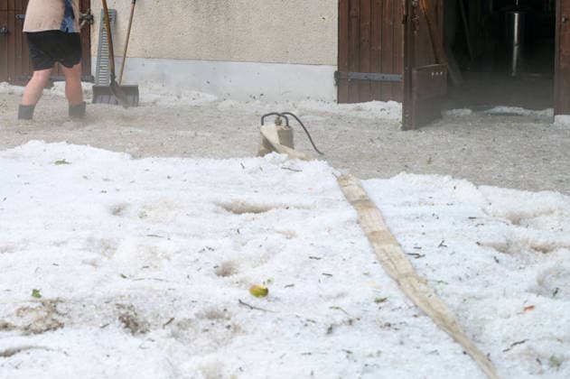 Hagelmassen in Monheim: Menschen greifen zu Schneeschippen, Heftige Unwetter haben in Monheim große Mengen Hagel niedergehen lassen. Straßen, Gehwege und Grundstücke waren stellenweise von einer dicken Schicht aus Hagelkörnern bedeckt das Bild erinnerte mitten im Sommer zeitweise an eine Winterlandschaft. Besonders eindrucksvoll: Anwohner greifen zu Schneeschippen und versuchen, die Hagelmassen von Straßen und Einfahrten zu räumen. Die ungewöhnlichen Bilder zeigen, welche Mengen innerhalb kurzer Zeit vom Himmel gefallen sind. Monheim Bayern Deutschland Monheim *** Heavy Hail in Monheim: People Grab Snow Shovels, Severe storms have dumped large amounts of hail in Monheim. Streets, sidewalks, and yards were covered in places by a t Copyright: x xonw-imagesx xSimonxZeiherx