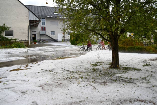 Hagelmassen in Monheim: Menschen greifen zu Schneeschippen, Heftige Unwetter haben in Monheim große Mengen Hagel niedergehen lassen. Straßen, Gehwege und Grundstücke waren stellenweise von einer dicken Schicht aus Hagelkörnern bedeckt das Bild erinnerte mitten im Sommer zeitweise an eine Winterlandschaft. Besonders eindrucksvoll: Anwohner greifen zu Schneeschippen und versuchen, die Hagelmassen von Straßen und Einfahrten zu räumen. Die ungewöhnlichen Bilder zeigen, welche Mengen innerhalb kurzer Zeit vom Himmel gefallen sind. Monheim Bayern Deutschland Monheim *** Heavy Hail in Monheim: People Grab Snow Shovels, Severe storms have dumped large amounts of hail in Monheim. Streets, sidewalks, and yards were covered in places by a t Copyright: x xonw-imagesx xSimonxZeiherx