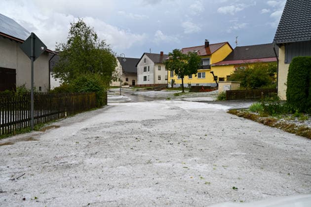 Hagelmassen in Monheim: Menschen greifen zu Schneeschippen, Heftige Unwetter haben in Monheim große Mengen Hagel niedergehen lassen. Straßen, Gehwege und Grundstücke waren stellenweise von einer dicken Schicht aus Hagelkörnern bedeckt das Bild erinnerte mitten im Sommer zeitweise an eine Winterlandschaft. Besonders eindrucksvoll: Anwohner greifen zu Schneeschippen und versuchen, die Hagelmassen von Straßen und Einfahrten zu räumen. Die ungewöhnlichen Bilder zeigen, welche Mengen innerhalb kurzer Zeit vom Himmel gefallen sind. Monheim Bayern Deutschland Monheim *** Heavy Hail in Monheim: People Grab Snow Shovels, Severe storms have dumped large amounts of hail in Monheim. Streets, sidewalks, and yards were covered in places by a t Copyright: x xonw-imagesx xSimonxZeiherx