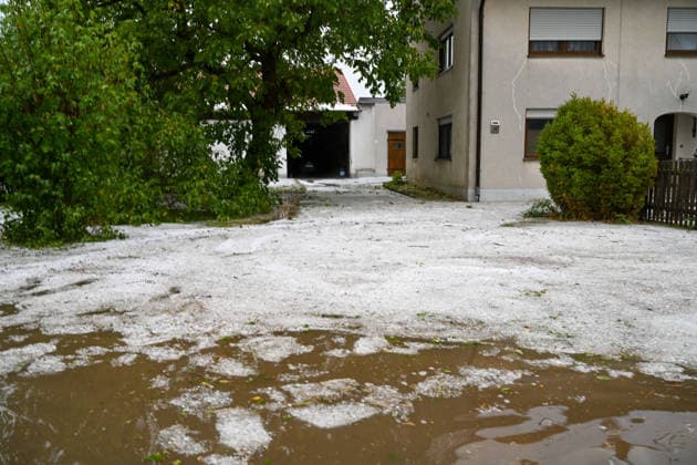 Hagelmassen in Monheim: Menschen greifen zu Schneeschippen, Heftige Unwetter haben in Monheim große Mengen Hagel niedergehen lassen. Straßen, Gehwege und Grundstücke waren stellenweise von einer dicken Schicht aus Hagelkörnern bedeckt das Bild erinnerte mitten im Sommer zeitweise an eine Winterlandschaft. Besonders eindrucksvoll: Anwohner greifen zu Schneeschippen und versuchen, die Hagelmassen von Straßen und Einfahrten zu räumen. Die ungewöhnlichen Bilder zeigen, welche Mengen innerhalb kurzer Zeit vom Himmel gefallen sind. Monheim Bayern Deutschland Monheim *** Heavy Hail in Monheim: People Grab Snow Shovels, Severe storms have dumped large amounts of hail in Monheim. Streets, sidewalks, and yards were covered in places by a t Copyright: x xonw-imagesx xSimonxZeiherx