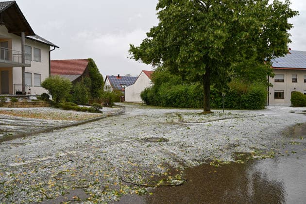 Hagelmassen in Monheim: Menschen greifen zu Schneeschippen, Heftige Unwetter haben in Monheim große Mengen Hagel niedergehen lassen. Straßen, Gehwege und Grundstücke waren stellenweise von einer dicken Schicht aus Hagelkörnern bedeckt das Bild erinnerte mitten im Sommer zeitweise an eine Winterlandschaft. Besonders eindrucksvoll: Anwohner greifen zu Schneeschippen und versuchen, die Hagelmassen von Straßen und Einfahrten zu räumen. Die ungewöhnlichen Bilder zeigen, welche Mengen innerhalb kurzer Zeit vom Himmel gefallen sind. Monheim Bayern Deutschland Monheim *** Heavy Hail in Monheim: People Grab Snow Shovels, Severe storms have dumped large amounts of hail in Monheim. Streets, sidewalks, and yards were covered in places by a t Copyright: x xonw-imagesx xSimonxZeiherx