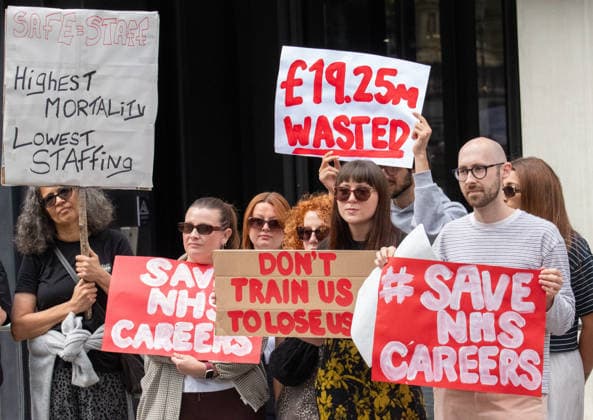 August 21, 2026, Manchester, United Kingdom: Protesters hold placards expressing their opinion during the demonstration. Unite Union members gather outside the UK government s Number 10 North regional headquarters at Heron House, 47 Lloyd Street, to protest against public funding waste and employment shortfalls in the NHS. Demonstrators carry placards saying Save NHS careers , 19.25 million wasted , and Highest mortality lowest staffing . The rally highlights a major jobs crisis facing newly qualified clinical psychologists and healthcare workers across the North West. Manchester United Kingdom - ZUMAs197 20260821_aaa_s197_074 Copyright: xGaryxRobertsx