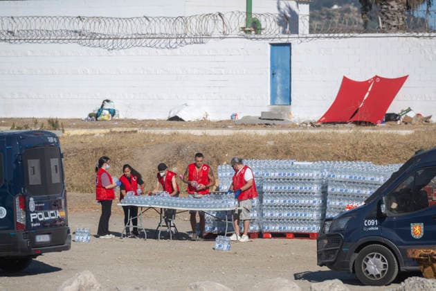 The humanitarian crisis in Ceuta continues. Red Cross members distribute water to migrants on a beach on August 21, 2026, in Ceuta, Spain. Ceuta continues to face a serious humanitarian crisis following the historic mass influx of more than 70,000 migrants who swam across the Tarajal on July 30 and 31. Although the police deployment and border reinforcement by Moroccan authorities have succeeded in curbing the influx, the autonomous city continues to face a serious humanitarian crisis, health, and security crisis. AUGUST 21, 2026 TRAMPOLÍN BEACH MIGRANTS IMMIGRANTS RED CROSS MIGRATION CRISIS PIXELATED Ceuta Ceuta, Spain  Copyright: xMarcosxMorenox 7724982