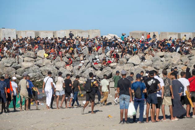 The humanitarian crisis in Ceuta continues. Red Cross members distribute food to migrants on a beach on August 21, 2026, in Ceuta, Spain. Ceuta continues to face a serious humanitarian crisis following the historic mass influx of more than 70,000 migrants who swam across the Tarajal on July 30 and 31. Although the police deployment and border reinforcement by by Moroccan authorities have managed to curb the influx, the autonomous city continues to face a serious humanitarian crisis, health, and security crises. AUGUST 21, 2026 TRAMPOLÍN BEACH MIGRANTS IMMIGRANTS RED CROSS MIGRATION CRISIS Ceuta Ceuta, Spain  Copyright: xMarcosxMorenox 7724963