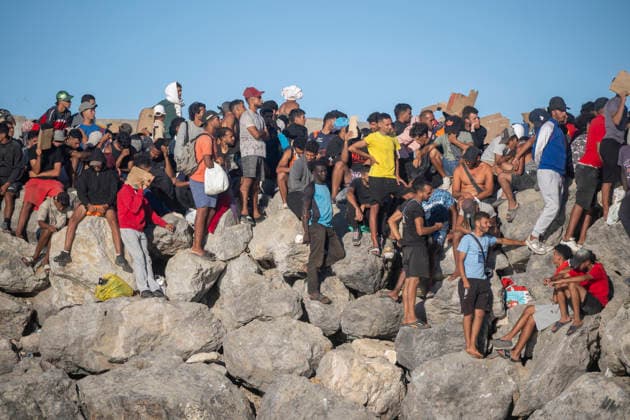 The humanitarian crisis in Ceuta continues. Red Cross members distribute food to migrants on a beach on August 21, 2026, in Ceuta, Spain. Ceuta continues to face a serious humanitarian crisis following the historic mass influx of more than 70,000 migrants who swam across the Tarajal Strait on July 30 and 31. Although the police deployment and border reinforcement by by Moroccan authorities have succeeded in curbing the influx, the autonomous city continues to face a serious humanitarian crisis, health, and security crises. AUGUST 21, 2026 TRAMPOLÍN BEACH MIGRANTS IMMIGRANTS RED CROSS MIGRATION CRISIS Ceuta Ceuta, Spain  Copyright: xMarcosxMorenox 7724971