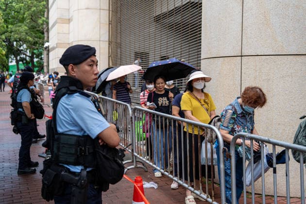 Hong Kong Court Verdit on Tiananmen Vigil Organizers Police officers stand guard next to people in line to enter the West Kowloon Magistrates Courts before the court hands down the verdict on the Tiananmen Vigil Organizers on August 20, 2026 in Hong Kong. A Hong Kong court today founded the organizers of the previous annual Tiananmen Vigil in Victoria Park guilty of inciting subversion. (Photo by Vernon Yuen Nexpher Images) HONG KONG