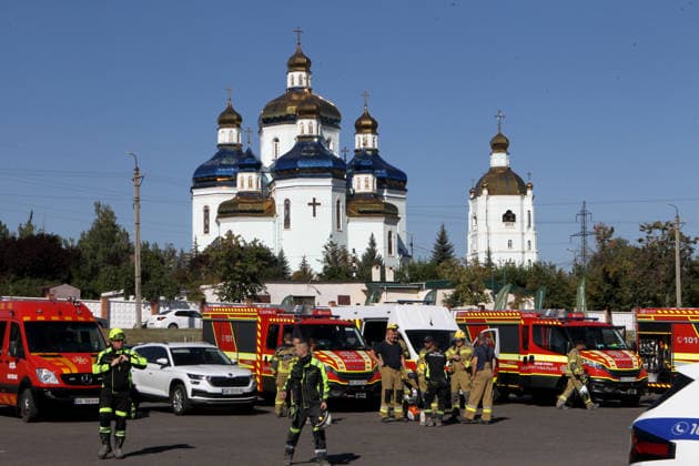 State Emergency Service rescue workers and special vehicles are parked outside Transfiguration Cathedral during a search-and-rescue at the Soniachna Halereia shopping and entertainment centre, damaged by a Russian drone strike in Kryvyi Rih, Ukraine, August 22, 2026. On Friday, August 21, Russian forces carried out a double drone attack on the city’s largest mall. Rescue and recovery operations are underway, with workers dismantling damaged reinforced concrete and metal structures and examining the rubble. Nine people, including two children, remain missing. A total of 130 civilians, among them 25 children, sustained injuries of varying severity, while the death toll has risen to 16. (Photo by Mykola Miakshykov Ukrinform) SAR operation ongo  Copyright: xMykolaxMiakshykovx