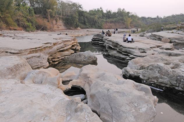 Rocky cliffs revealed after water level drop in Bogowonto River of Purworejo PURWOREJO, CENTRAL JAVA - AUGUST 22: Residents observe rocks and the rocky riverbed as the water level of the Bogowonto River drops during the dry season in Purworejo, Central Java, on August 22, 2026. The riverbed reveals unique wadas rock formations and natural rock carvings created by water erosion, resembling a miniature Grand Canyon stretching one kilometer. The river’s low water level is a result of the five-month-long dry season; normally, the Bogowonto River’s water level reaches five to six meters, covering the rocks and cliffs. Dasril Roszandi Anadolu Purworejo Indonesia. Editorial use only. Please get in touch for any other usage.  Copyright: x2026xAnadoluxDasrilxRoszandix