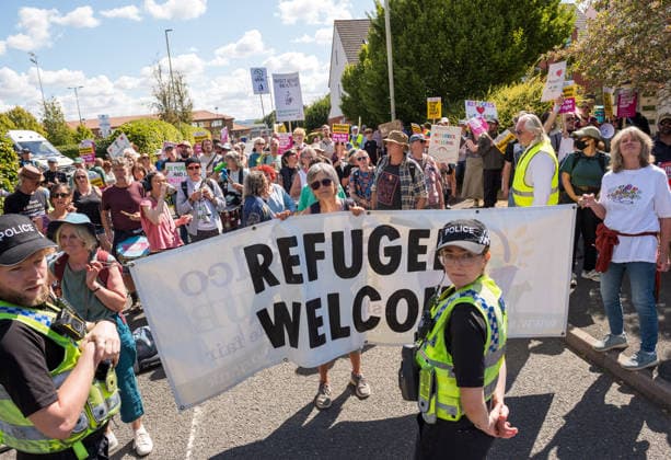 August 22, 2026, Gloucester, Gloucestershire, UK: Gloucester, UK. Counter protesters hold up a sign reading Ã¢â‚¬oeREFUGEES WELCOMEÃ¢â‚¬Â while a group called Gloucester Patriots protest outside the Ibis Hotel in Bristol where asylum seekers and migrants are being accommodated. Gloucester UK  - ZUMAl94_ 20260822_zaf_l94_007 Copyright: xSimonxChapmanx