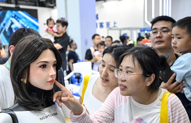 (260822) -- BEIJING, Aug. 22, 2026 -- People view a humanoid robot at the 2026 World Robot Conference in Beijing, capital of China, Aug. 22, 2026. The conference, which runs from Wednesday through Sunday, has drawn more than 300 exhibitors from 26 countries, with over 3,000 products on display, including more than 300 debuts. Many people visited the conference on Saturday, the first open day of the event. ) CHINA-BEIJING-WORLD ROBOT CONFERENCE (CN) ChenxYehua 