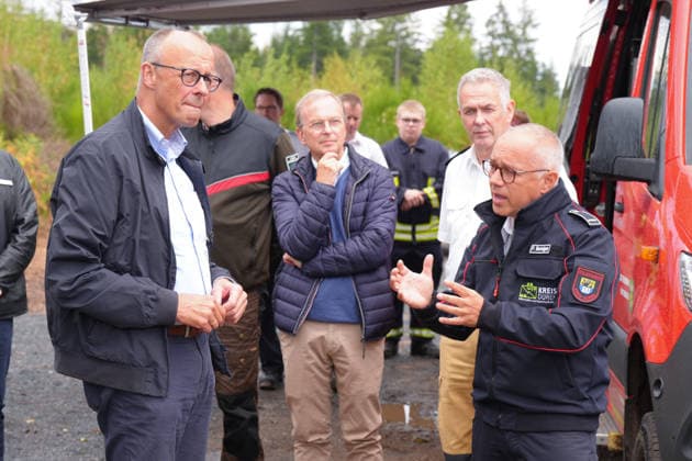 Bundeskanzler Merz besucht Waldbrandgebiet Huertgenwald Feuerwehrsprecher peter Berndgen gemeinsam mit Bundeskanzler Friedrich Merz bei der Besichtigung des ehemaligen Waldbrandgebiet in Huertgenwald, , 22.08.2026 Huertgenwald (Kreis Dueren) Nordrhein-Westfalen Deutschland *** Chancellor Merz Visits the Huertgenwald Forest Fire Area Fire department spokesperson Peter Berndgen with Chancellor Friedrich Merz during a tour of the former forest fire area in Huertgenwald, August 22, 2026, Huertgenwald, Düren District, North Rhine-Westphalia, Germany