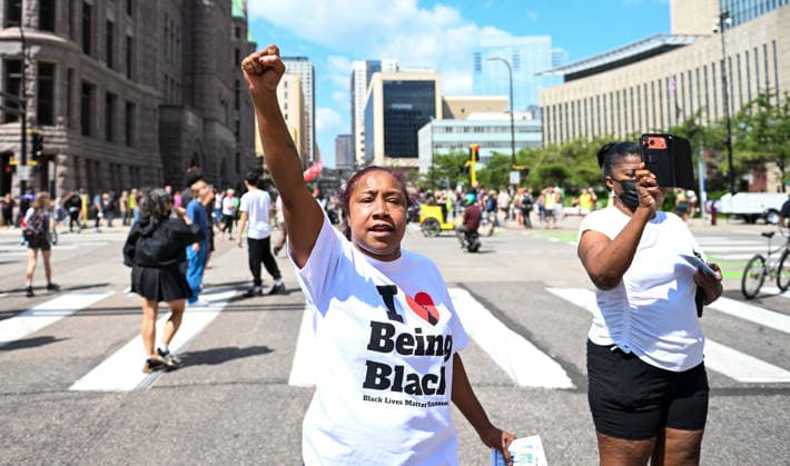 August 22, 2026, Minneapolis, Minnesota, USA: A demonstrator holds their fist in the air as a supporter of conservative influencer, Jake Lang is chased off in downtown Minneapolis on Saturday, August 22nd, 2026. Minneapolis USA - ZUMAd171 20260822_znp_d171_003 Copyright: xSethxDonovanx
