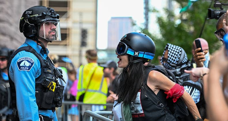 August 22, 2026, Minneapolis, Minnesota, USA: A demonstrator confronts a police officer after Minneapolis police arrested a protestor in response to a crowd standing up to far-right influencer, Jake Lang coming through Minneapolis on Saturday, August 22nd, 2026. Minneapolis USA - ZUMAd171 20260822_znp_d171_006 Copyright: xSethxDonovanx