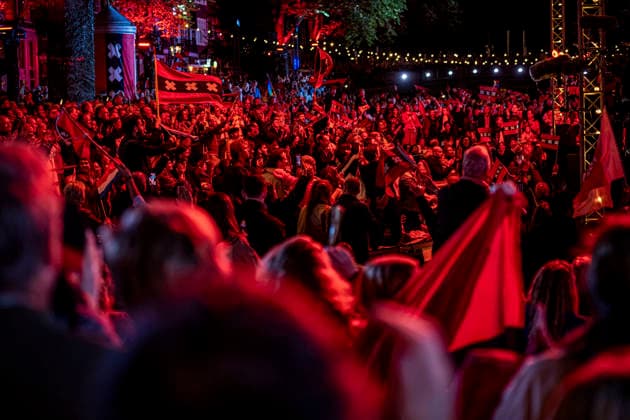 August 22, 2026, Amsterdam, North Holland, The Netherlands: Audience members wave the flag of the city of Amsterdam as musicians perform the song De Stad Amsterdam (The City of Amsterdam). 22 August 2026, in Amsterdam, the Netherlands. The 44th edition of the Prinsengrachtconcert takes place on a floating stage on the Prinsengracht in front of Hotel Pulitzer, the largest free open-air classical music concert in the Netherlands. Amsterdam The Netherlands - ZUMAp202 20260822_zip_p202_023 Copyright: xJamesxPetermeierx