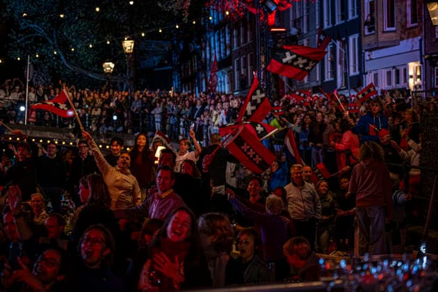 August 22, 2026, Amsterdam, North Holland, The Netherlands: Audience members wave the flag of the city of Amsterdam as musicians perform the song De Stad Amsterdam (The City of Amsterdam). 22 August 2026, in Amsterdam, the Netherlands. The 44th edition of the Prinsengrachtconcert takes place on a floating stage on the Prinsengracht in front of Hotel Pulitzer, the largest free open-air classical music concert in the Netherlands. Amsterdam The Netherlands - ZUMAp202 20260822_zip_p202_054 Copyright: xJamesxPetermeierx