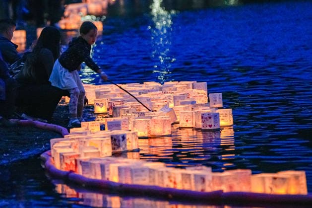 (260823) -- COQUITLAM, Aug. 23, 2026 -- A girl releases an illuminated lantern onto the water during the Water Lantern Festival at Town Centre Park in Coquitlam, British Columbia, Canada, Aug. 22, 2026. The festival invited participants to decorate lanterns with messages of hope, dreams and remembrance before releasing them onto the water. (Photo by Xinhua) CANADA-COQUITLAM-WATER LANTERN FESTIVAL LiangxSen 