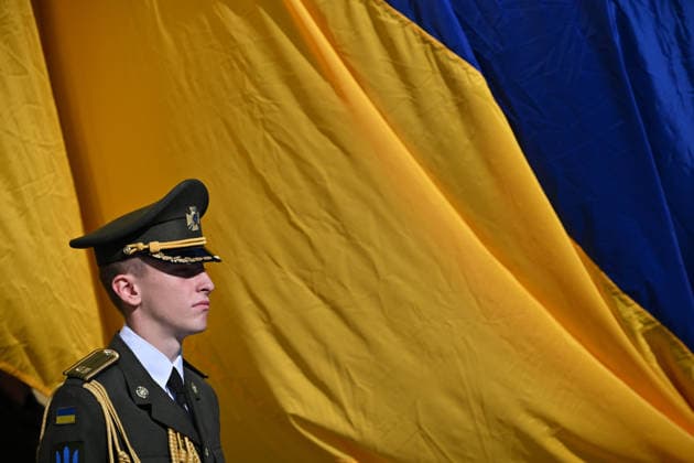 National Flag Day of Ukraine in Lviv LVIV, UKRAINE - AUGUST 23: A Ukrainian serviceman stands in front of a large Ukrainian flag during a National Flag Day ceremony in Lviv, Ukraine, on August 23, 2026. Due to the ongoing Russian-Ukrainian War, celebrations were limited to a ceremonial raising of the Ukrainian flag on the city s highest flagpole with the participation of soldiers from various branches of the armed forces. Participants also observed a minute of silence for those killed, sang the Ukrainian national anthem, and listened to patriotic and folk songs performed by a military orchestra. Michael Sorrow Anadolu Lviv Ukraine. Editorial use only. Please get in touch for any other usage.  Copyright: x2026xAnadoluxMichaelxSorrowx