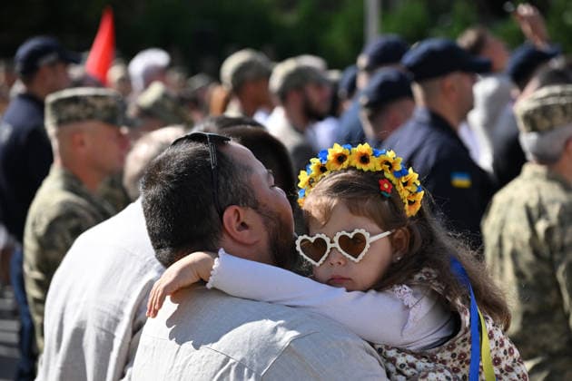 National Flag Day of Ukraine in Lviv LVIV, UKRAINE - AUGUST 23: A child wearing a floral wreath in the colors of the Ukrainian flag is carried by a man during a National Flag Day ceremony in Lviv, Ukraine, on August 23, 2026. Due to the ongoing Russian-Ukrainian War, celebrations were limited to a ceremonial raising of the Ukrainian flag on the city s highest flagpole with the participation of soldiers from various branches of the armed forces. Participants also observed a minute of silence for those killed, sang the Ukrainian national anthem, and listened to patriotic and folk songs performed by a military orchestra. Michael Sorrow Anadolu Lviv Ukraine. Editorial use only. Please get in touch for any other usage.  Copyright: x2026xAnadoluxMichaelxSorrowx