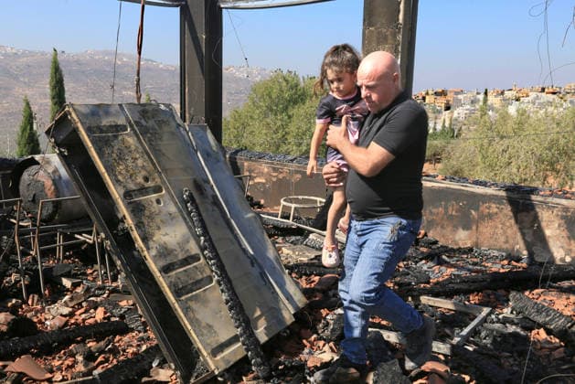 August 23, 2026, Nablus, West Bank, Palestine: A Palestinian man carries his daughter amidst the rubble of his home after it was set on fire following an attack by a group of Jewish settlers in the village of Osarin, south of Nablus in the West Bank. The settlers attacked homes, torched a Palestinian car in the early morning hours, and wrote Hebrew slogans on the walls calling for revenge against Palestinians. Nablus Palestine  - ZUMAs197 20260823_aaa_s197_029 Copyright: xNasserxishatyehx