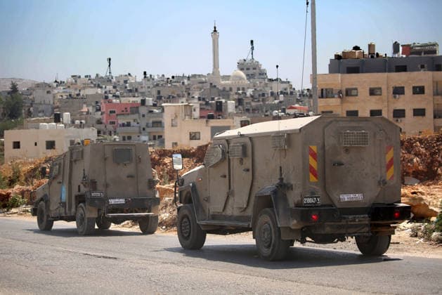 Palestinian-Israeli conflict in Nablus, Palestine - 23 Aug 2026 Israeli military vehicles seen passing by buildings in the Askar refugee camp. Ajouri was killed during an Israeli military operation in the Askar refugee camp. Israeli forces raided Palestinian shops and homes. A Palestinian medical source reported that a 15-year-old boy was killed by Israeli fire and two others were wounded during stone-throwing clashes in the Askar refugee camp. Nablus Palestine Copyright: xNasserxishatyehx xSOPAxImagesx Nishtayeh179
