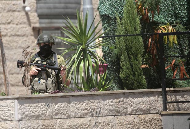 Palestinian-Israeli conflict in Nablus, Palestine - 23 Aug 2026 An Israeli soldier takes up position in a flower garden during a military operation in the Askar refugee camp. Ajouri was killed during an Israeli military operation in the Askar refugee camp. Israeli forces raided Palestinian shops and homes. A Palestinian medical source reported that a 15-year-old boy was killed by Israeli fire and two others were wounded during stone-throwing clashes in the Askar refugee camp. Nablus Palestine Copyright: xNasserxishatyehx xSOPAxImagesx Nishtayeh183