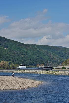 23.8.2026 Dürre Der extrem niederige Wasserstand des Rhein. Große Teile des Binger Lochs an de Nahemündung liegen trocken. Die Menschen spazieren dort wo sonst meterhoch das Wasser fließt. Die Fahrrinne für die Schifffahrt ist nur eingeschränkt nutzbar. Bingen Rhein Rheinland Pfalz Deutschland *** August 23, 2026 Drought The water level of the Rhine is extremely low. Large parts of the Binger Loch at the mouth of the Nahe are dry. People are walking where the water would normally flow meters high. The shipping channel is only partially usable. Bingen, Rhine, Rhineland-Palatinate, Germany
