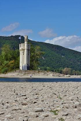 23.8.2026 Dürre Der extrem niederige Wasserstand des Rhein. Große Teile des Binger Lochs an de Nahemündung liegen trocken. Die Menschen spazieren dort wo sonst meterhoch das Wasser fließt. Die Fahrrinne für die Schifffahrt ist nur eingeschränkt nutzbar. Bingen Rhein Rheinland Pfalz Deutschland *** August 23, 2026 Drought The water level of the Rhine is extremely low. Large parts of the Binger Loch at the mouth of the Nahe are dry. People are walking where the water would normally flow meters high. The shipping channel is only partially usable. Bingen, Rhine, Rhineland-Palatinate, Germany