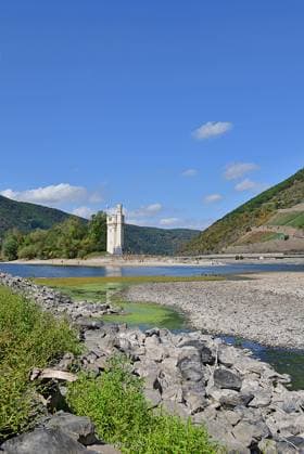 23.8.2026 Dürre Der extrem niederige Wasserstand des Rhein. Große Teile des Binger Lochs an de Nahemündung liegen trocken. Die Menschen spazieren dort wo sonst meterhoch das Wasser fließt. Die Fahrrinne für die Schifffahrt ist nur eingeschränkt nutzbar. Bingen Rhein Rheinland Pfalz Deutschland *** August 23, 2026 Drought The water level of the Rhine is extremely low. Large parts of the Binger Loch at the mouth of the Nahe River are dry. People are walking where the water would normally flow several meters high. The shipping channel is only partially usable. Bingen, Rhine, Rhineland-Palatinate, Germany