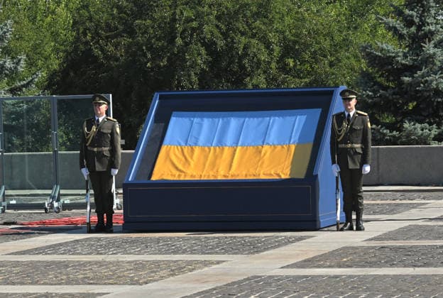 Honour guards flank the historical flag of Ukraine, known as the Independence Flag, which was brought into the session hall of the Ukrainian Parliament in the first moments after the declaration of independence of Ukraine on August 24, 1991, during the ceremony to raise the State Flag at the National Museum of the History of Ukraine in the Second World War Memorial Complex on National Flag Day, Kyiv, Ukraine, August 23, 2026. (Photo by Yevhen Kotenko Ukrinform) Raising of State Flag of Ukraine in Kyiv  Copyright: xYevhenxKotenkox
